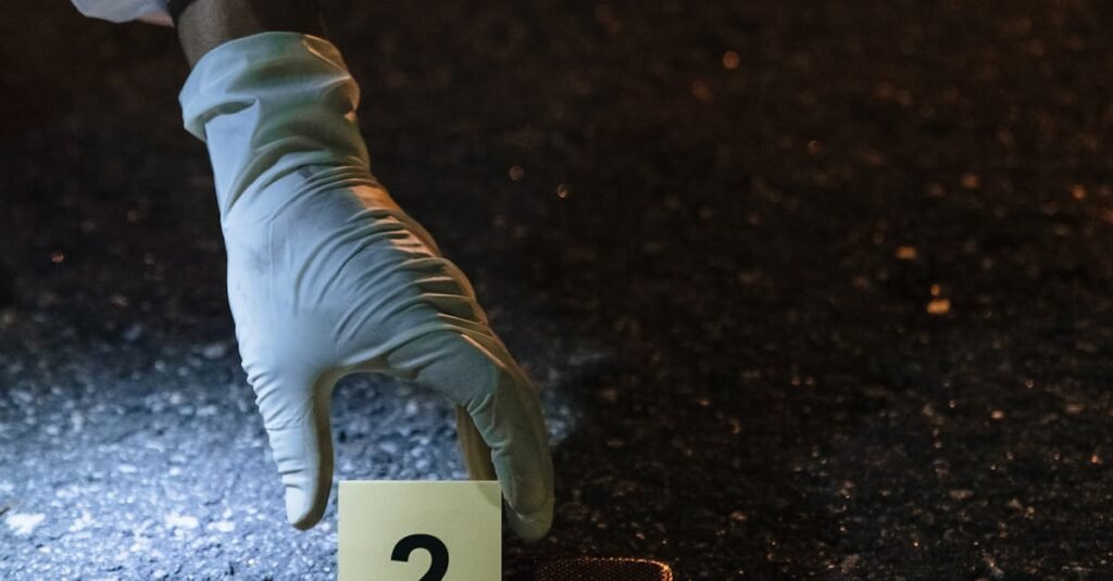 A forensic investigator examines evidence at a night crime scene on city streets.